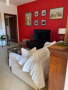 ein Wohnzimmer mit einem Sofa und einer roten Wand in der Unterkunft Casa~Lu in Mentana
