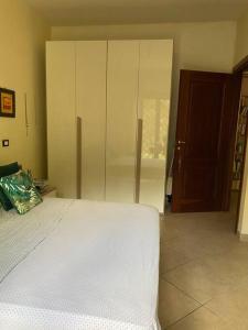 ein Schlafzimmer mit einem weißen Bett und einem Kleiderschrank in der Unterkunft Casa~Lu in Mentana