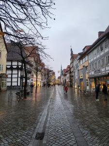 Una calle de la ciudad bajo la lluvia con gente caminando en JASTA Homes: Altstadt-Apartment en Hameln