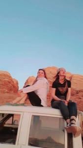 three women sitting on the back of a truck at Talal Wadi Rum in Wadi Rum