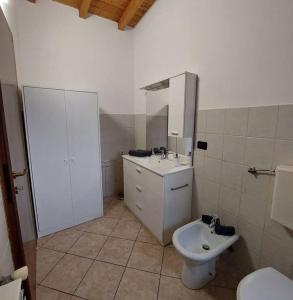 een witte badkamer met een toilet en een wastafel bij Smile Home! Graziosa casa con parcheggio e giardino in Bovísio-Masciago Milanese