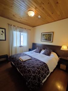 1 dormitorio con 1 cama grande y ordenador portátil en Las Retamas B&B en Ushuaia