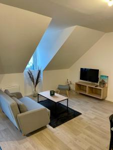 un soggiorno con divano e TV di L'escapade a Fougères