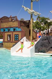 two children playing on a slide at a water park at H10 Suites Lanzarote Gardens in Costa Teguise