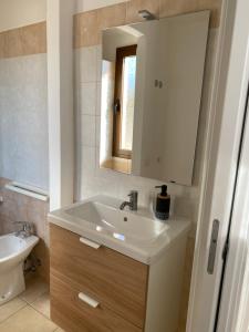 a bathroom with a sink and a mirror at La Collina: Il maestrale in Castiadas