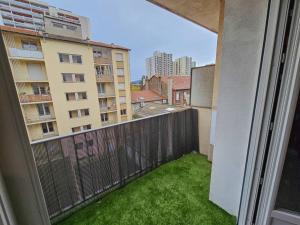 Cet appartement dispose d'un balcon avec une cour verdoyante et des bâtiments. dans l'établissement Le Bergson 3 chambres Stationnement gratuit, à Saint-Étienne