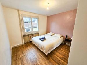 サン・テティエンヌにあるLe Bergson 3 chambres Stationnement gratuitの窓のある大きな白いベッドのある寝室