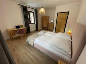 a bedroom with a large white bed and a desk at Dom na Słowiańskiej in Szczawno-Zdrój
