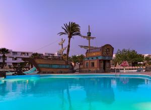 a large swimming pool in a resort with a clock at H10 Suites Lanzarote Gardens in Costa Teguise