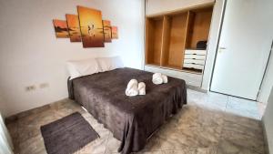 1 dormitorio con 1 cama con 2 zapatillas en Alojamientos Litoral - Dpto San José en Gualeguaychú