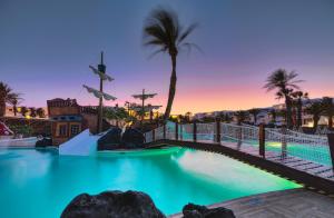 a pool at a resort with palm trees at H10 Suites Lanzarote Gardens in Costa Teguise