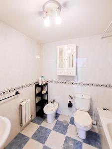 uma casa de banho com um WC e um lavatório em Apartamento, piscina y parking Granada Tico Medina em Granada