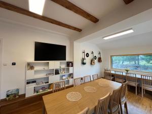 a dining room with a table and a flat screen tv at Penzion Stará pošta in Dubí