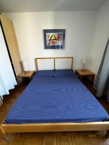 una camera con un letto blu con due tavoli di Paradise Lake View a Paradiso