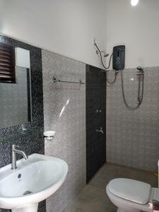 a bathroom with a sink and a toilet at All View Resort in Tangalle