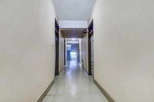 菩提伽耶的住宿－Collection O Hotel Aaradhya Heritage，白色墙壁和白色地板的建筑走廊