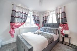 a bedroom with a large bed with pink curtains at *RA98BL* For your most relaxed & Cosy stay + Free Parking + Free Fast WiFi * in Farnley
