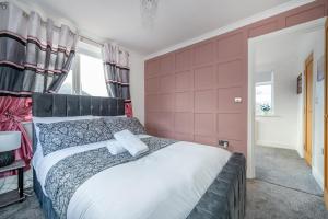 a bedroom with a large bed with a red wall at *RA98BL* For your most relaxed & Cosy stay + Free Parking + Free Fast WiFi * in Farnley