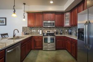 a kitchen with wooden cabinets and stainless steel appliances at Luxury Downtown Rental (Hot Tub/Pet Friendly) - La Dolce Vita Villas #10 in Moab