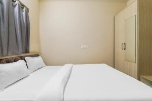 ein Schlafzimmer mit einem weißen Bett und einer Tür in der Unterkunft Super OYO Hotel Rameshwar in Ranchi