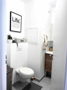 a white bathroom with a toilet and a sink at Wander Saint Ouen in Saint-Ouen