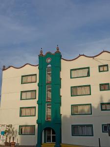 un edificio verde con un reloj encima en Hotel Tres Torres en Morelia