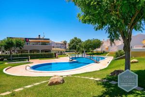 een zwembad in een park met een boom bij Villa Rafaella 3 Dream Lodging in Albufeira