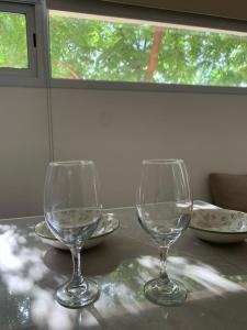 deux verres à vin assis au-dessus d'une table dans l'établissement Las Tipas mini loft Cafayate, à Cafayate