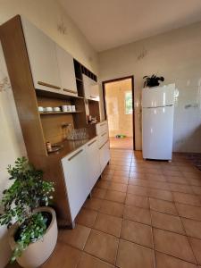 eine Küche mit Kühlschrank und Fliesenboden in der Unterkunft Canto das Montanhas in Aiuruoca