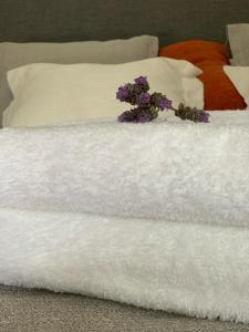 - un bouquet de fleurs assis au-dessus d'un lit blanc dans l'établissement Las Tipas mini loft Cafayate, à Cafayate