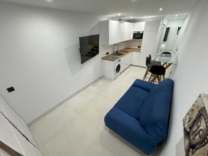 sala de estar con sofá azul y cocina en Fuente Dulce, en Orzola