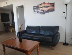 a living room with a black leather couch and a coffee table at Apartamento 2 Cuartos 1 Bano in Victoria