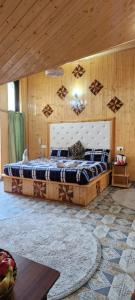 1 dormitorio con 1 cama grande y techo de madera en Behtereen resort, en Srinagar