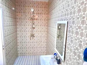 a bathroom with a sink and a mirror at Appartement meublé avec Spa jacuzzi privatif in Mbour