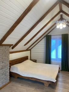 a bedroom with a large bed in a attic at Лучка in Mykulychyn