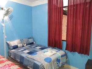 - une chambre dotée d'un lit avec des murs bleus et des rideaux rouges dans l'établissement Depa - 204, à Moyobamba