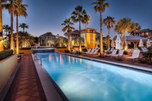 una grande piscina con sedie e palme di Peek A Boo View a Inlet Beach