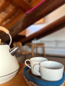 維琴察的住宿－L’Abbaino，桌子上放两个杯子和茶壶