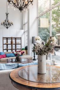 un salon avec un vase et des fleurs sur une table dans l'établissement Art Suites Athens, à Athènes