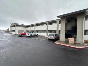 un estacionamiento con autos estacionados frente a un edificio en Desert Sands Inn & Suites, en Albuquerque
