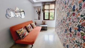 a living room with an orange couch and a floral wall at Wide Family Apartment in the new Center of Casablanca in Casablanca