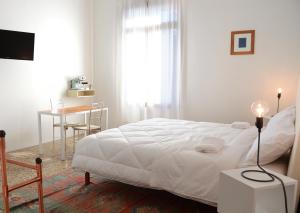 a white bedroom with a bed and a table and a desk at B&B Giardino Jappelli (Villa Ca' Minotto) in Rosà