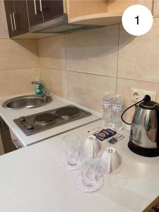 W kuchni znajduje się blat z kieliszkami i czajnik do herbaty. w obiekcie Ideal KH apartments w Charkowie