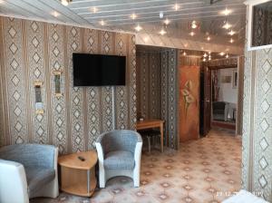 a living room with a tv on a wall at Central Hotel in Schwetzingen