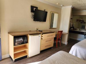 a hotel room with a tv on the wall at Budget Inn in Corcoran