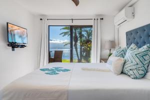 a bedroom with a bed with a view of the ocean at Lauloa 105 in Wailuku