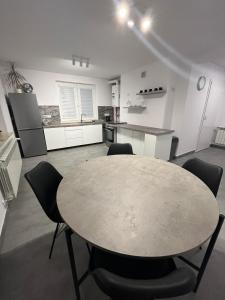 uma cozinha com mesa e cadeiras num quarto em Piasecki Apartamenty em Lublin