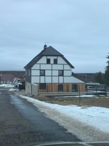 a large white house with a black roof at Penzion Stará pošta in Dubí