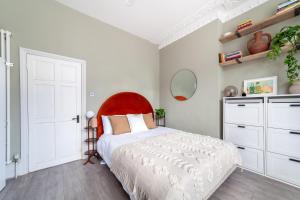 a bedroom with a large bed with a red headboard at Arte Stays - 2 Bed Luxurious Flat, Garden, 5min Dalston st., Parking Available, Serviced Accommodation - up to 5 ppl in London