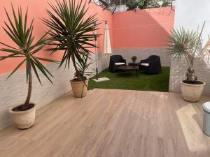 a room with two palm trees and a table and chairs at Magnifique Appart OCEAN BLEU in Dakar